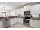 Bright kitchen featuring white cabinets, granite countertops, stainless steel appliances, and natural light at 130 50Th St, Holmes Beach, FL 34217