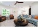 Cozy living room featuring a plush blue sectional, round wooden coffee table, and bright natural light at 130 50Th St, Holmes Beach, FL 34217