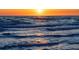 The sun sets over the ocean waves at 130 50Th St, Holmes Beach, FL 34217