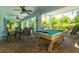Outdoor patio with dining table, pool table, and fans for comfortable entertaining at 130 50Th St, Holmes Beach, FL 34217