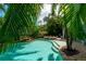 Beautiful outdoor pool, hot tub and landscaped backyard surrounded by lush tropical greenery at 130 50Th St, Holmes Beach, FL 34217