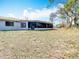 Spacious backyard featuring a covered lanai and mature trees at 13365 Drayton Dr, Spring Hill, FL 34609