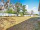 View of a backyard featuring mature trees and a white fence at 13365 Drayton Dr, Spring Hill, FL 34609