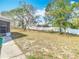 View of spacious backyard featuring mature trees and a white fence at 13365 Drayton Dr, Spring Hill, FL 34609