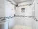 A newly renovated bathroom with white marbled tiles and a mosaic shower trim at 13365 Drayton Dr, Spring Hill, FL 34609