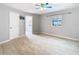 Bright bedroom with modern flooring, ceiling fan, and a view into an attached bathroom at 13365 Drayton Dr, Spring Hill, FL 34609
