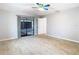 A spacious room with tiled floor, ceiling fan, and a sliding glass door to an outdoor patio at 13365 Drayton Dr, Spring Hill, FL 34609