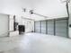 Spacious garage interior with utility closet, large garage door, and concrete floors at 13365 Drayton Dr, Spring Hill, FL 34609