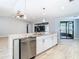 Modern kitchen island with stainless steel dishwasher and sink, plus white cabinetry at 13365 Drayton Dr, Spring Hill, FL 34609