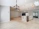 Open floor plan with kitchen island, breakfast bar, tile flooring and modern light fixtures at 13365 Drayton Dr, Spring Hill, FL 34609