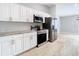 Modern kitchen featuring white cabinetry, stainless steel appliances, and tile backsplash at 13365 Drayton Dr, Spring Hill, FL 34609