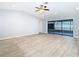 Spacious living area featuring wood-look tile flooring and sliding glass doors to the screened-in lanai at 13365 Drayton Dr, Spring Hill, FL 34609