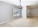 Bright living room with wood-look tile floor, large window and contemporary light fixture at 13365 Drayton Dr, Spring Hill, FL 34609