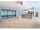 Open-concept living room with tile floors, screened-in lanai access, and modern kitchen at 13365 Drayton Dr, Spring Hill, FL 34609