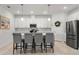 Bright kitchen featuring white cabinets, stainless steel appliances, and an island with barstool seating at 15246 Serene Shores Loop, Bradenton, FL 34211