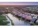 Stunning aerial view of homes along the water and golf course at sunset at 15606 Leven Links Pl, Lakewood Ranch, FL 34202