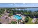 Aerial view of a pool, hot tub and large lake with fountain, surrounded by lush landscaping, and community residences at 15606 Leven Links Pl, Lakewood Ranch, FL 34202