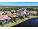 Aerial view of a community with tile roofs, screened-in pools, and scenic water views at 15606 Leven Links Pl, Lakewood Ranch, FL 34202