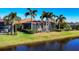 Scenic backyard view with a pond, palm trees, and screened-in lanai, ideal for relaxing outdoors at 15606 Leven Links Pl, Lakewood Ranch, FL 34202
