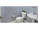 Powder room featuring a marble-look accent wall and pedestal sink at 15606 Leven Links Pl, Lakewood Ranch, FL 34202