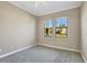 A modest bedroom with neutral paint and carpet with two windows to the outside at 15606 Leven Links Pl, Lakewood Ranch, FL 34202