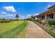 The beautiful clubhouse borders a golf course and is surrounded by manicured landscaping and palm trees at 15606 Leven Links Pl, Lakewood Ranch, FL 34202