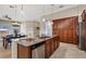 Kitchen island featuring stainless steel appliances, granite countertops and wooden cabinetry at 15606 Leven Links Pl, Lakewood Ranch, FL 34202