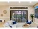Bright living room with a view of the screened-in patio, pool, and golf course beyond at 15606 Leven Links Pl, Lakewood Ranch, FL 34202