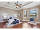Serene main bedroom with tray ceiling, hardwood floors, and tranquil golf course view at 15606 Leven Links Pl, Lakewood Ranch, FL 34202