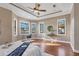 Spacious main bedroom featuring tray ceilings, hardwood floors, and abundant natural light at 15606 Leven Links Pl, Lakewood Ranch, FL 34202