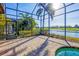 Enclosed patio and paver decking overlook lush landscaping and a scenic lake at 15606 Leven Links Pl, Lakewood Ranch, FL 34202