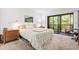 Cozy bedroom featuring a comfortable bed, bedside table, and a screened in lanai overlooking a leafy view at 1615 Clower Creek Dr # 177, Sarasota, FL 34231