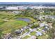 Aerial view of neighborhood with a pond and bridge, surrounded by mature trees and green spaces at 1622 17Th E St, Bradenton, FL 34208