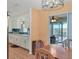 Bright kitchen with white cabinetry, blue backsplash, modern lighting fixture, and sliding glass doors to the outdoor space at 1622 17Th E St, Bradenton, FL 34208
