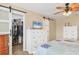 Bedroom showcasing a closet with a sliding barn door, dresser with TV, and comfortable bed at 1622 17Th E St, Bradenton, FL 34208