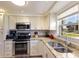 Well-lit kitchen features granite counters, stainless steel appliances, and a view from the large window at 3053 Concord St, Sarasota, FL 34231