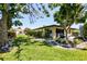Backyard with green grass and shrubbery between lawn and house with adjacent golf course at 3208 Vivienda Blvd, Bradenton, FL 34207