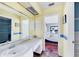 Bathroom with light yellow walls, blue accent stripe, long countertop, and a view to the main bedroom at 3208 Vivienda Blvd, Bradenton, FL 34207
