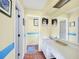 Bright bathroom with tile flooring, artwork, and a long vanity with integrated sink and mirror at 3208 Vivienda Blvd, Bradenton, FL 34207