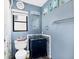 Blue bathroom with decorative tile and glass bowl sink on a modern vanity with a clock above at 3208 Vivienda Blvd, Bradenton, FL 34207