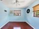Empty bedroom with wood floors, blue walls, and a ceiling fan with an overhead light at 3208 Vivienda Blvd, Bradenton, FL 34207