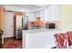 Cozy kitchen features white cabinetry, stainless steel refrigerator, and terracotta tiled floor at 3208 Vivienda Blvd, Bradenton, FL 34207