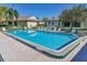Community pool with lounge chairs, lush landscaping, and clear blue water at 3208 Vivienda Blvd, Bradenton, FL 34207