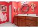 Bright red bathroom with a cherry vanity, unique mirror, and seashell decorations at 3296 Tallywood Ct # 7097, Sarasota, FL 34237