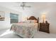 Bright bedroom featuring a ceiling fan, colorful bedding, and a large window with lush view at 3296 Tallywood Ct # 7097, Sarasota, FL 34237