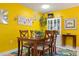 Bright dining area with vibrant yellow walls, classic wood furniture, and eye-catching decor at 3296 Tallywood Ct # 7097, Sarasota, FL 34237