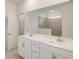 Bright bathroom featuring a double sink vanity, large mirror, and a walk-in shower with neutral-toned tile at 3603 Night Star Terrace, Parrish, FL 34219