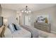 Serene bedroom featuring modern lighting, neutral paint, a dresser and an ensuite bathroom entrance at 3603 Night Star Terrace, Parrish, FL 34219