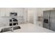A modern white kitchen featuring stainless steel appliances, quartz countertops, pantry, and a stainless steel sink at 3603 Night Star Terrace, Parrish, FL 34219