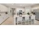 Bright, all-white kitchen featuring a large quartz island, stainless steel appliances, and tile flooring with bar seating at 3603 Night Star Terrace, Parrish, FL 34219